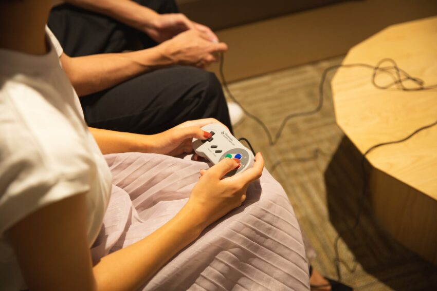 unrecognizable couple playing video game with gamepads at home