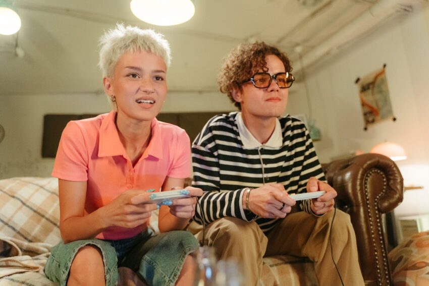 couple sitting on sofa and playing video game